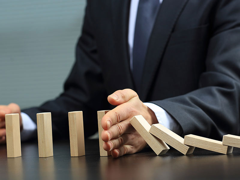 homme faisant tomber des dominos