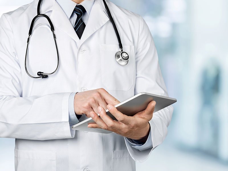 médecin en blouse blanche consultant une tablette